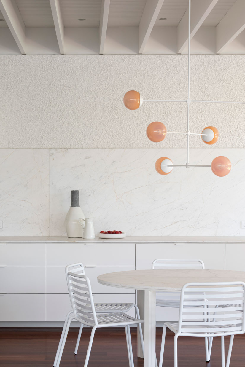 Melbourne Architects. Subtle textures of white combine with pink hues of the flooring and lighting at the meals table.